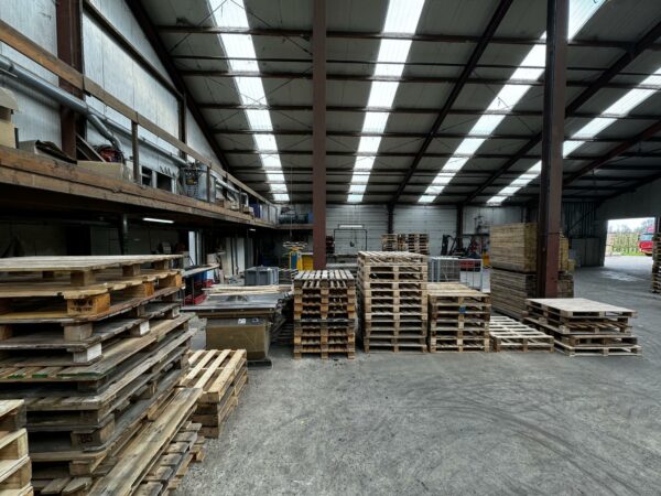 Stapel houten pallets in een ruime loods aan de Graaf van Lynden van Sandenburgweg.